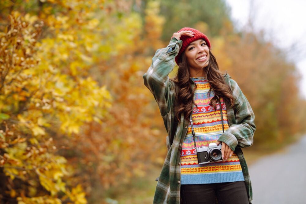 Красива молода жінка фотографується з ретро-камерою. Відпочинок, релаксація, подорожі, стиль життя.